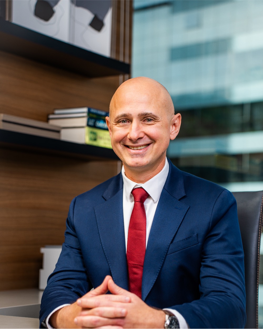 Retrato corporativo de profissional sorrindo, sentado à mesa de reunião